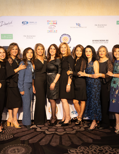 Large group of people posing in front of the event backdrop.