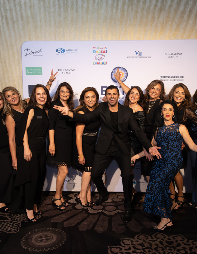 Large group of people posing in front of the event backdrop.