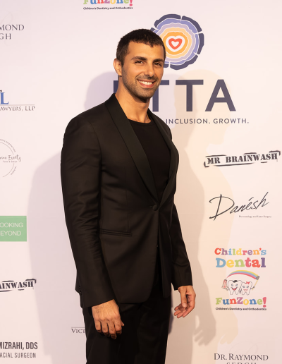 1 man posing in front of the event backdrop.