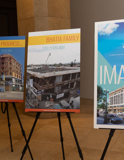 4 large posters displayed on easels in a hall.