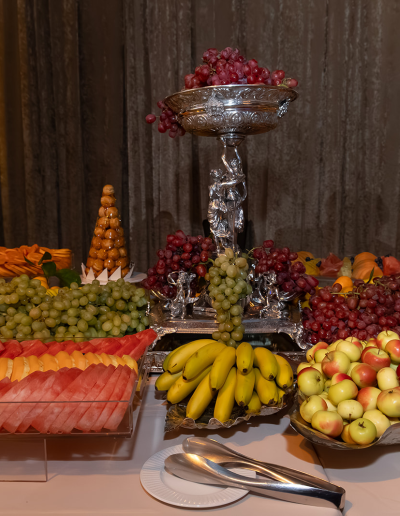 Buffet table with neatly arranged trays of fruit.