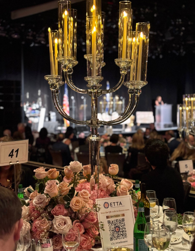Table centerpiece with tall candles and flowers.